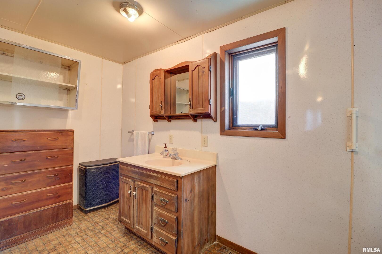 2002 Garfield Street Clinton, IA 52732 - Photo 11 of 19 a bathroom with a sink a vanity and a mirror