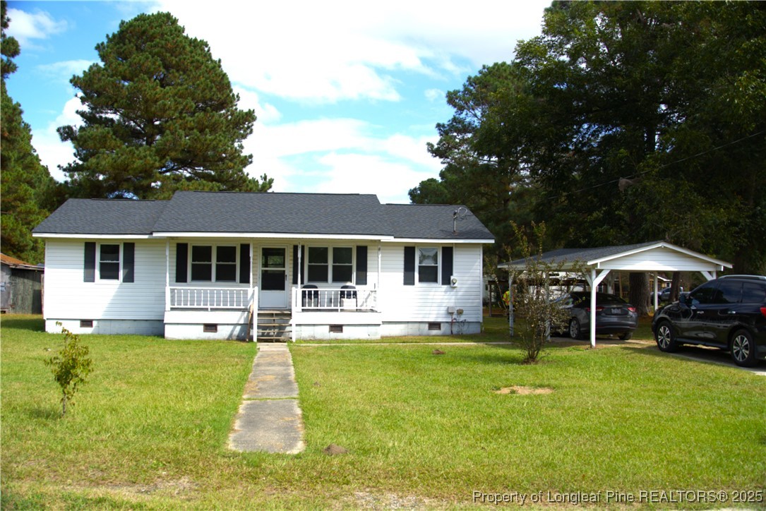 a view of a house with a yard deck and a large tree