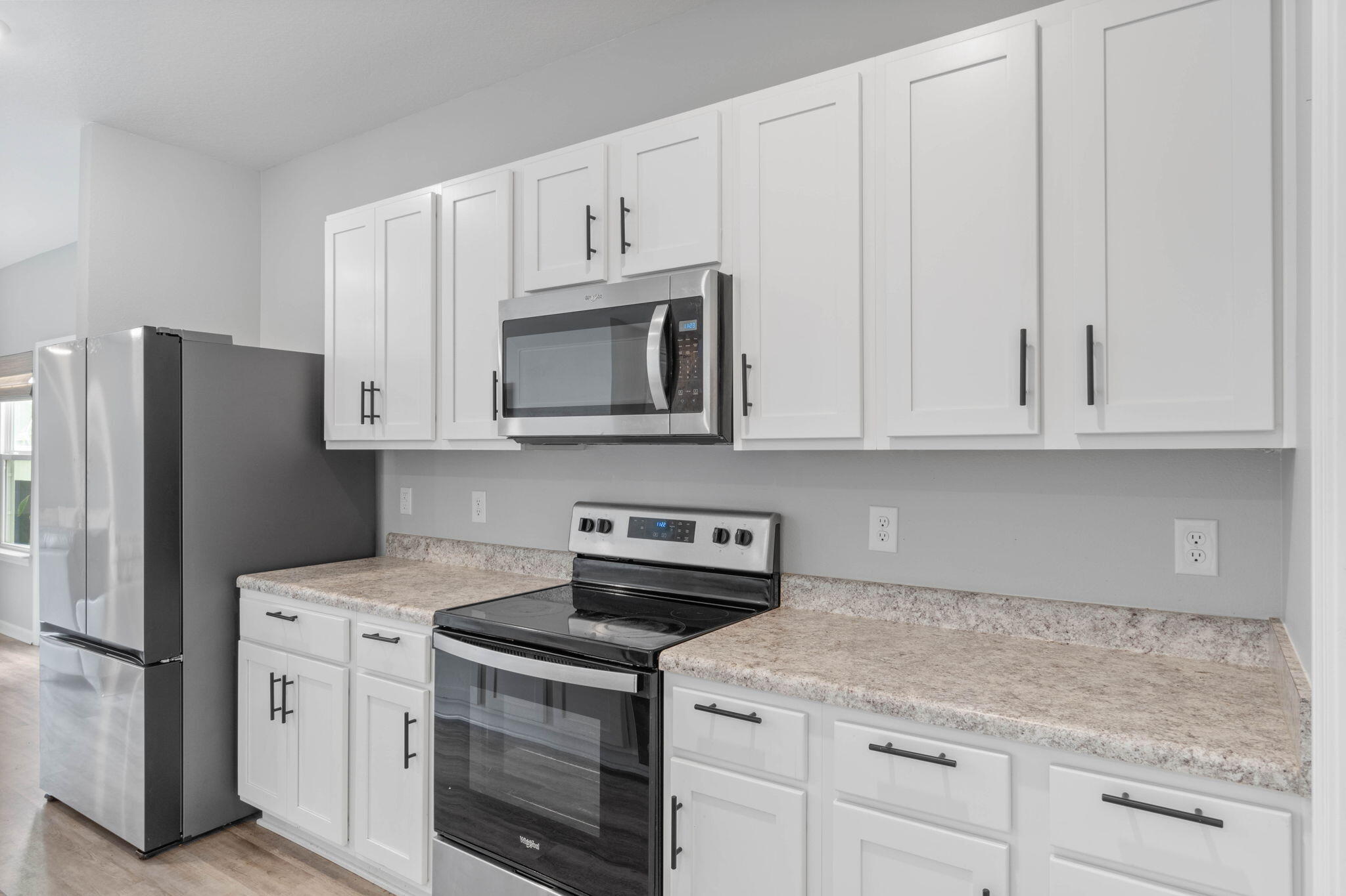 38 Silverthorn Street Freeport, FL 32439 - Photo 12 of 42 a kitchen with white cabinets and stainless steel appliances