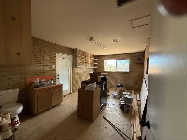 a view of a kitchen with a sink and dishwasher a stove top oven with wooden floor