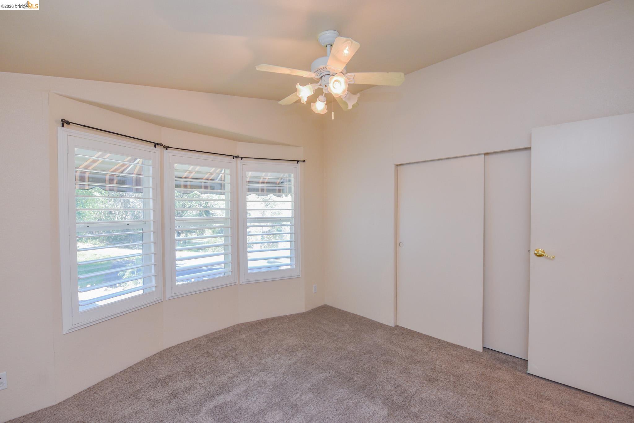 23732 Parrotts Ferry Road, Unit 47 Columbia, CA 95310 - Photo 14 of 21 Unfurnished bedroom with a closet, a ceiling fan, and carpet