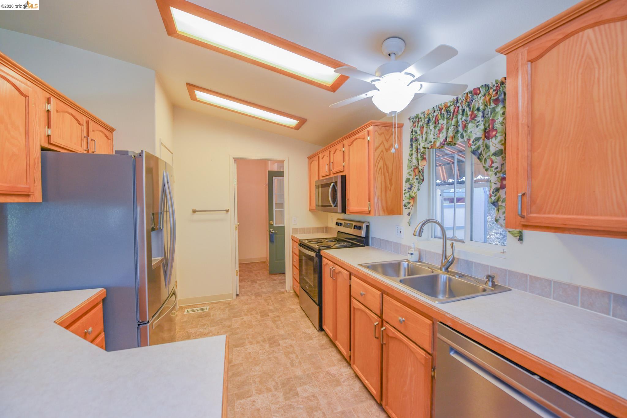23732 Parrotts Ferry Road, Unit 47 Columbia, CA 95310 - Photo 16 of 21 Kitchen with light countertops, stainless steel appliances, lofted ceiling, and ceiling fan