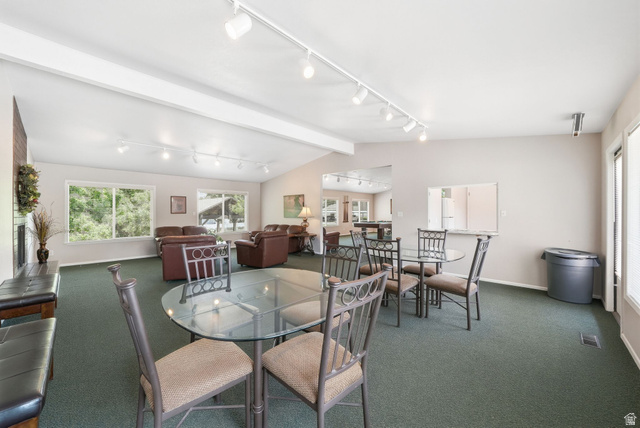 6969 South 855 East Midvale, UT 84047 - Photo 46 of 55 Spacious gathering room featuring vaulted ceilings, track lighting, an integrated service window, multiple windows, and a brick-detailed fireplace