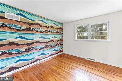 a view of empty room with wooden floor