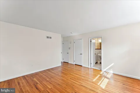 a view of empty room with wooden floor