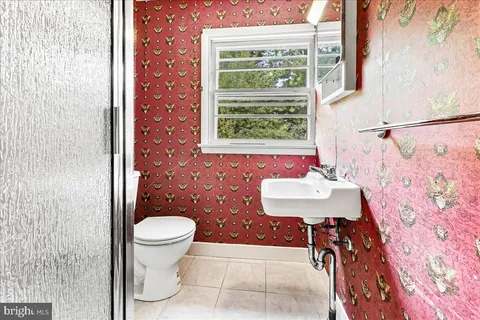 an empty room with windows a fireplace and wooden floor