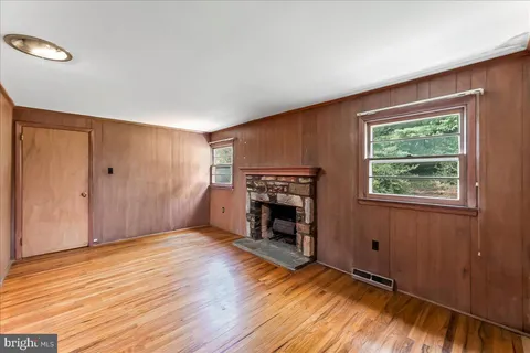 a view of empty room with wooden floor and fireplace