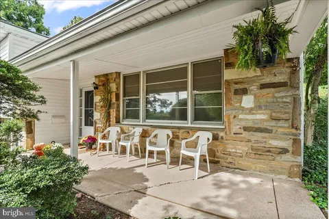 a view of a porch with a table and chairs and potted plants