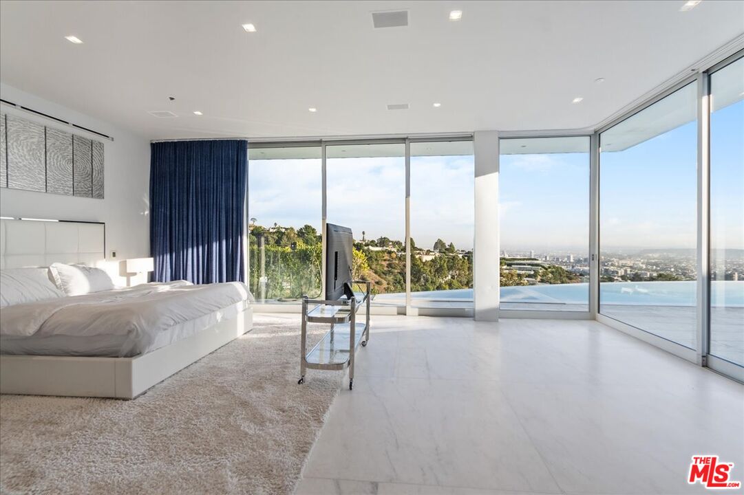 1620 Carla Ridge Beverly Hills, CA 90210 - Photo 20 of 42 a living room with couch and a floor to ceiling window