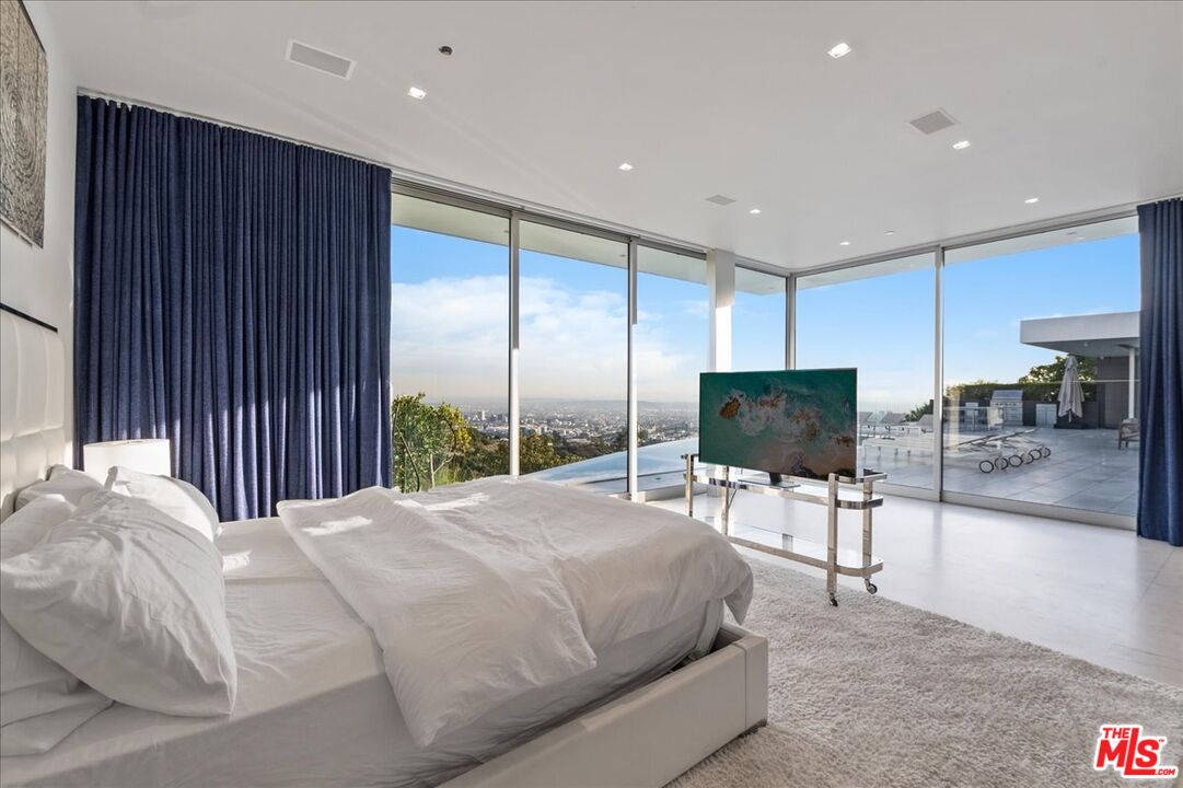 1620 Carla Ridge Beverly Hills, CA 90210 - Photo 21 of 42 a bedroom with a bed and a flat screen tv