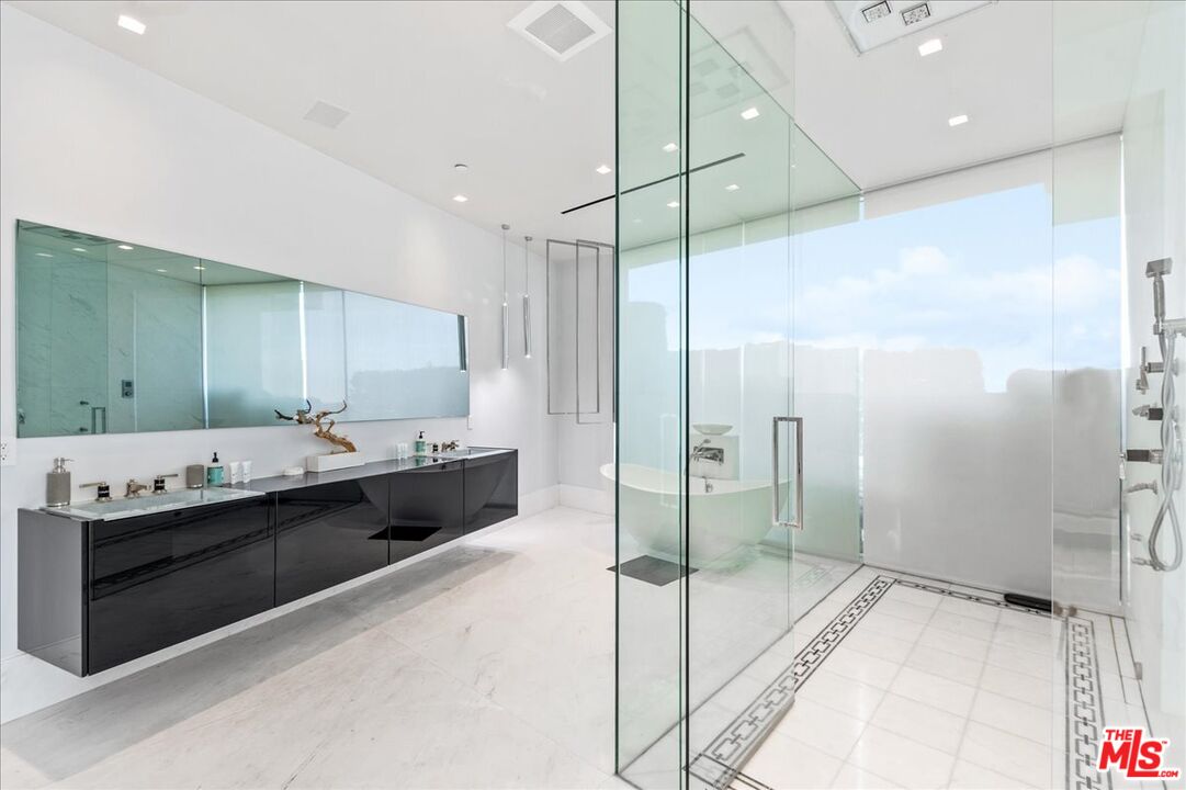 1620 Carla Ridge Beverly Hills, CA 90210 - Photo 22 of 42 a bathroom with a granite countertop sink mirror and shower