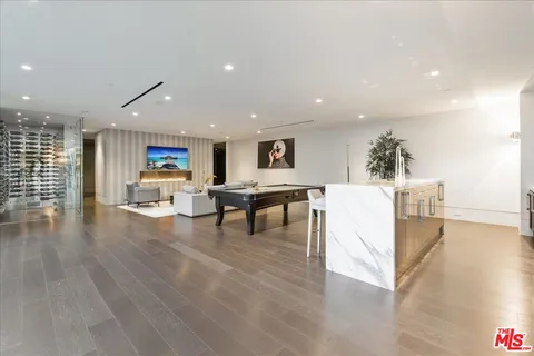 a view of a kitchen with kitchen island a stove a table and a refrigerator