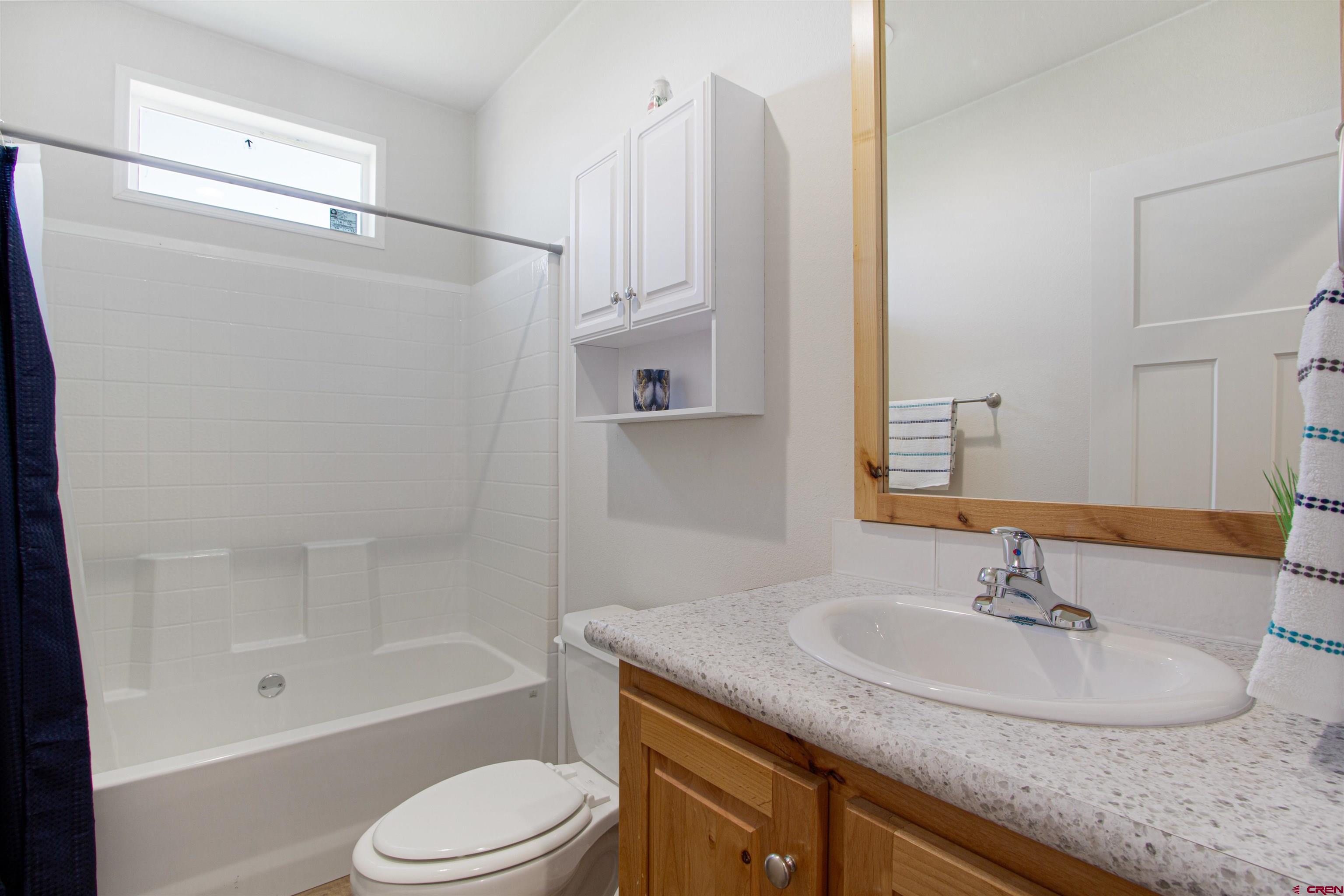 62069 Jade Road Montrose, CO 81401 - Photo 13 of 29 a bathroom with a granite countertop sink toilet and shower