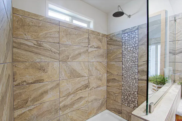 a white bath tub sitting in a bathroom next to a window