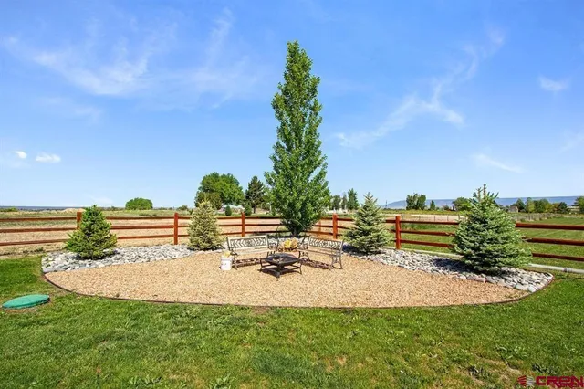 a view of a tiny house with a big yard and large trees