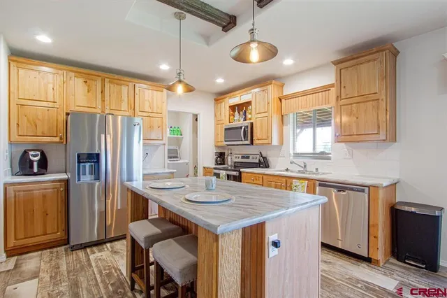 a kitchen with stainless steel appliances granite countertop a sink a refrigerator and a stove
