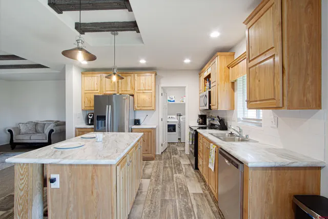 a kitchen with a stove a refrigerator a sink dishwasher with wooden cabinets and wooden floor