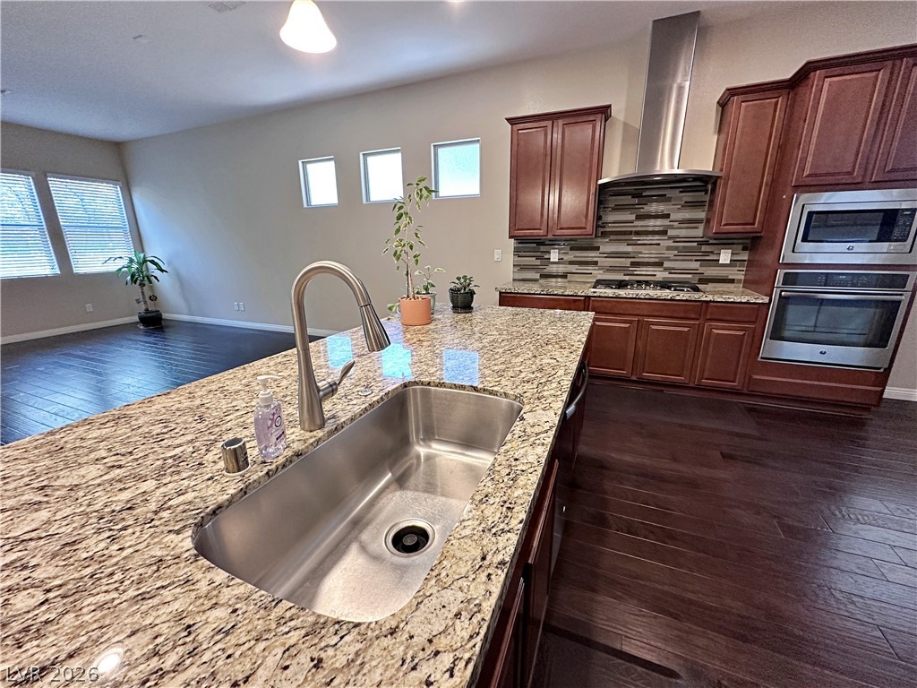 71 Newton Ridge Way Las Vegas, NV 89183 - Photo 18 of 40 A chef's dream kitchen offers a spacious island, built-in appliances, and rich wood flooring.