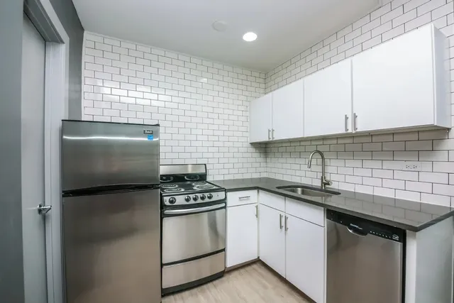 a kitchen with stainless steel appliances a sink stove and cabinets
