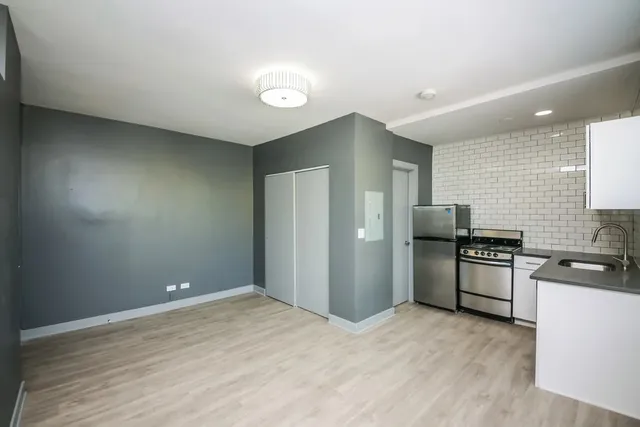 a kitchen with stainless steel appliances granite countertop a refrigerator and a stove top oven