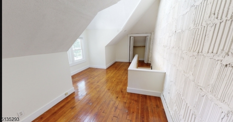 40-42 Dunnell Road Maplewood, NJ 07040 - Photo 11 of 11 a view of a hallway with wooden floor and staircase