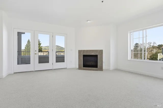 a view of an empty room with a fireplace and a window