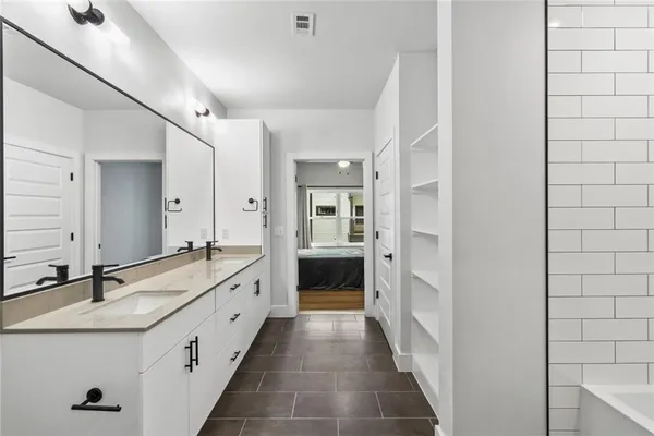a spacious bathroom with a double vanity sink and a mirror