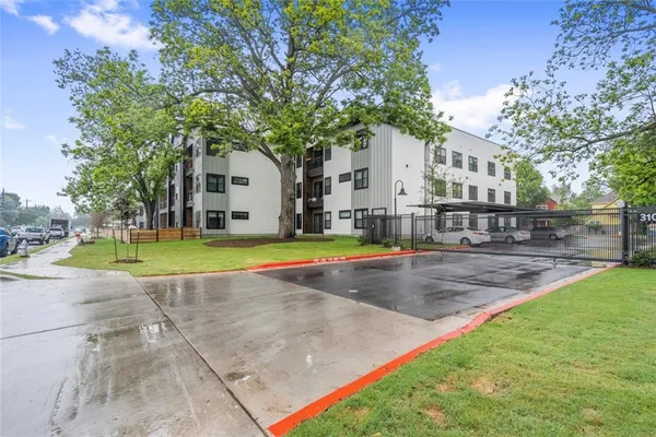 a view of a white house with a big yard and palm trees
