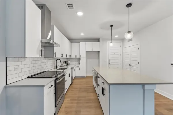 a kitchen with white cabinets and stainless steel appliances