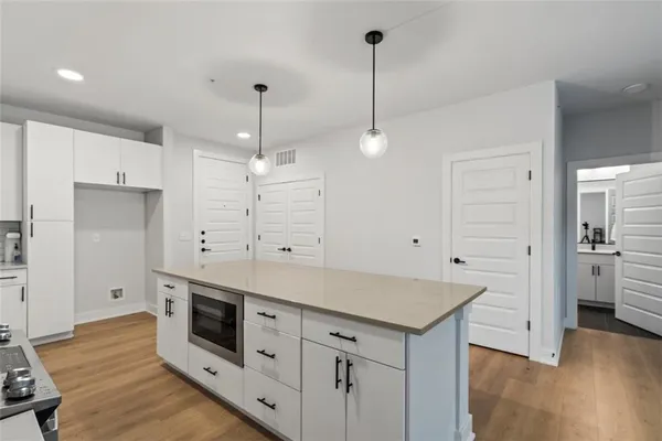 a kitchen with stainless steel appliances a stove a sink a chandelier and a refrigerator