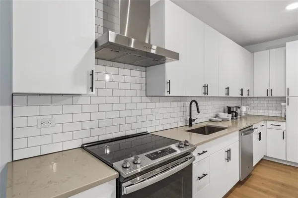 a kitchen with a sink stove and cabinets