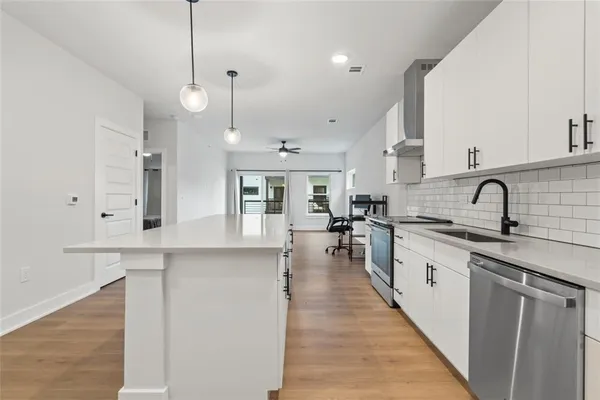a large kitchen with stainless steel appliances lots of counter space and a sink