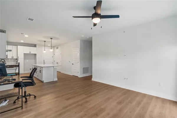 a view of a kitchen with furniture and wooden floor