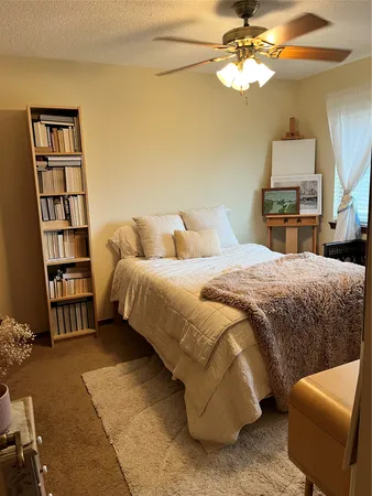 a bedroom with a bed a dresser next to a window