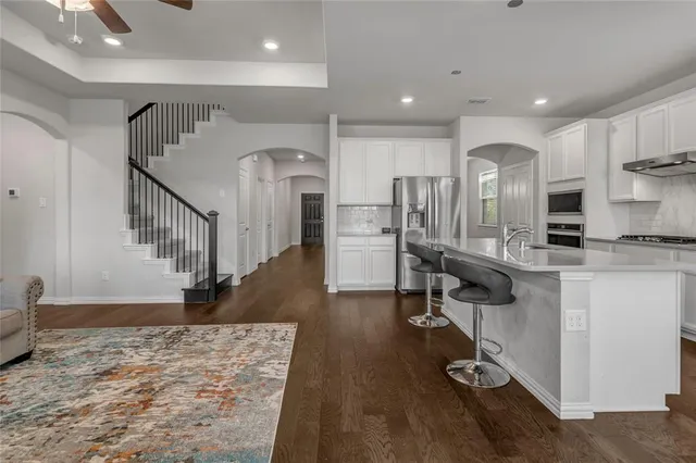 a view of kitchen with refrigerator microwave and stove top oven