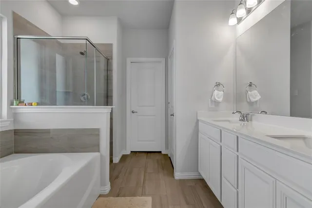 a bathroom with a tub sink and mirror