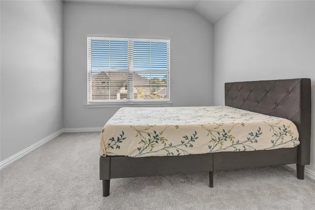 a large bed sitting in a bedroom next to a window