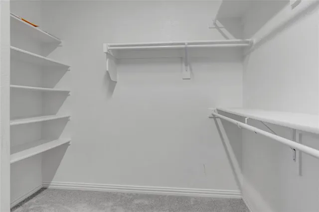 a view of walk in closet with empty racks