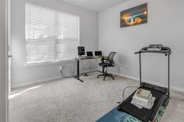 a view of a workspace with furniture and a window