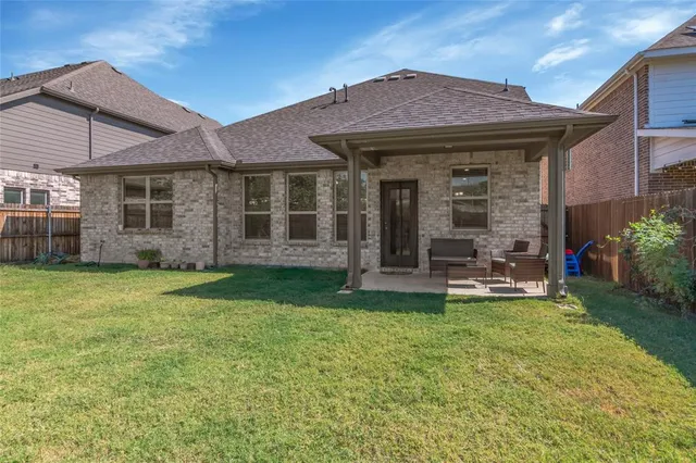 a view of a house with a yard potted plants and a table