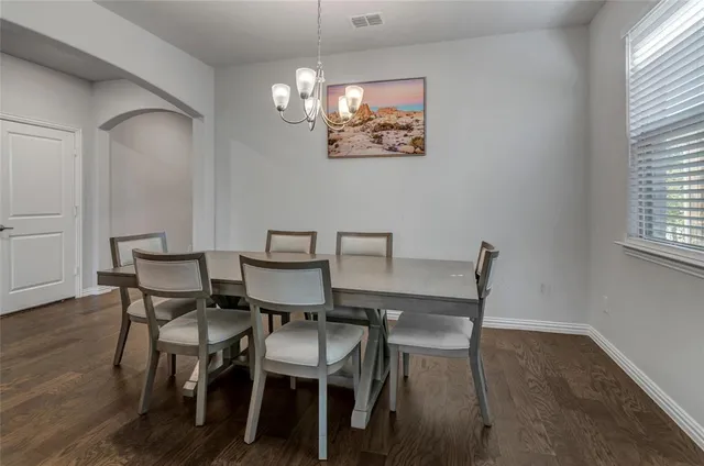 a view of a dining room with furniture a chandelier and wooden floor