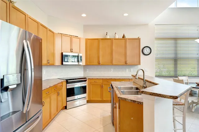 a kitchen with stainless steel appliances granite countertop a sink a refrigerator and a stove