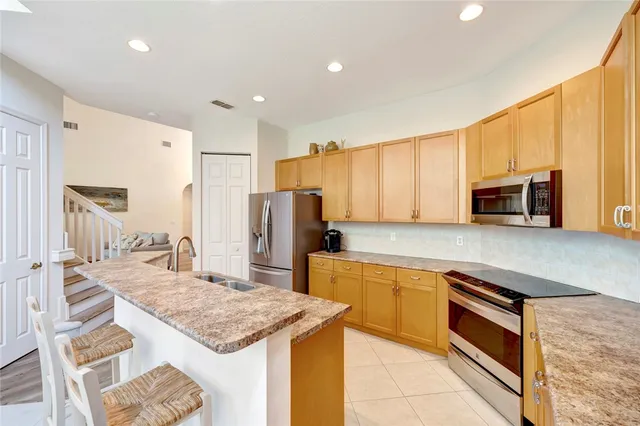 a kitchen with stainless steel appliances granite countertop a refrigerator and microwave