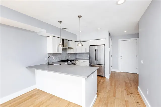 a kitchen with stainless steel appliances a refrigerator a sink a stove a microwave and island