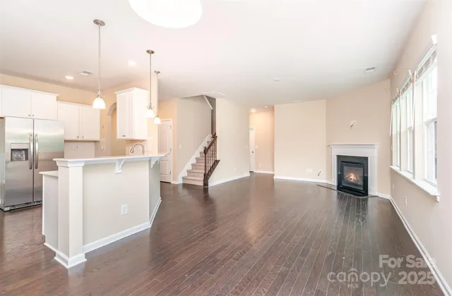 a view of a kitchen with a fridge and wooden floor