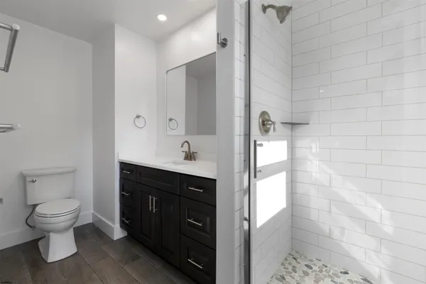 a bathroom with a granite countertop sink a toilet and a mirror