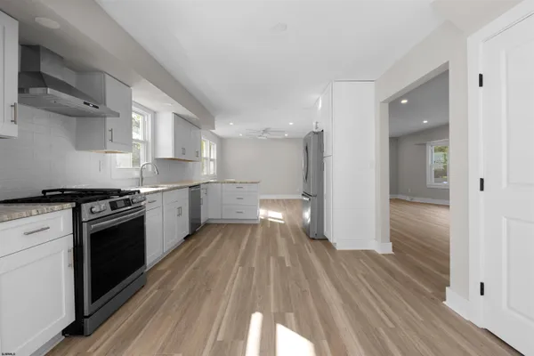 a kitchen with stainless steel appliances granite countertop a stove a sink and a microwave