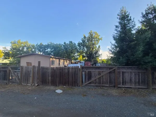 a view of a house with wooden fence next to a road