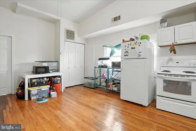 a kitchen with a refrigerator and wooden floor