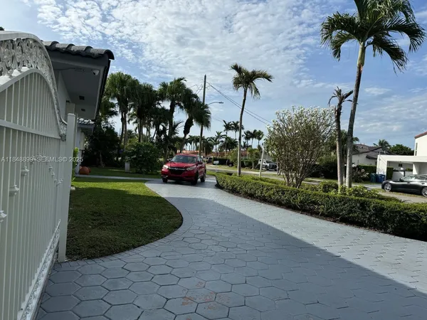 a view of a street with a cars parked and small park
